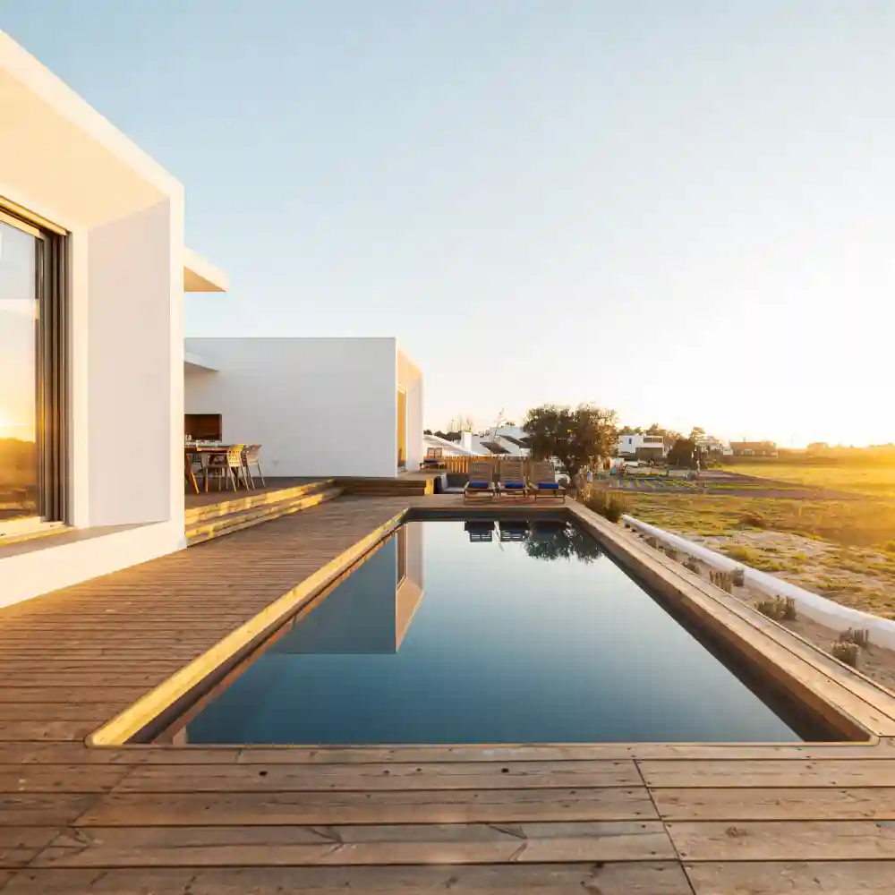 Aerial view of a modern villa with a flat rooftop and rectangular swimming pool