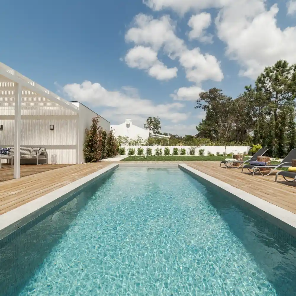 Contemporary villa with a backyard pool surrounded by lush greenery