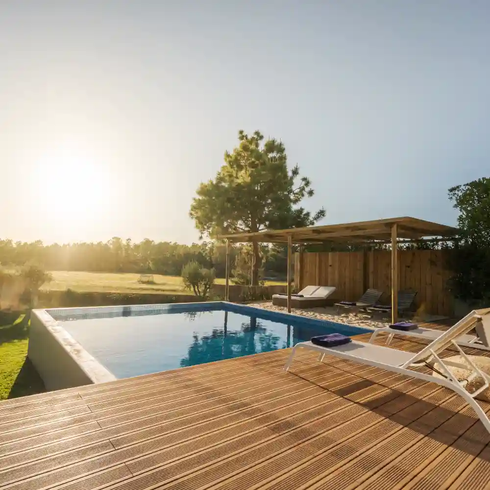 Long rectangular swimming pool surrounded by a tiled walkway in a luxury home