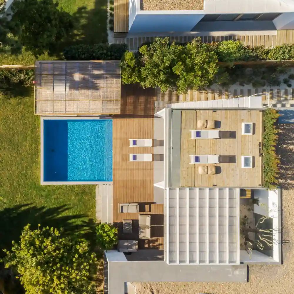 Outdoor terrace of a modern house with poolside seating and warm lighting